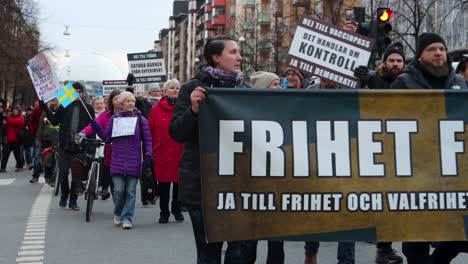 Protesters-with-signs,-flags-and-banners-at-Covid-march-in-Stockholm