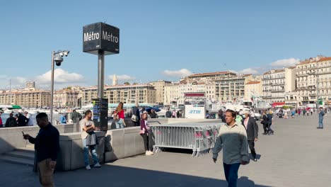 People-walk-by-metro-station-by-Old-Port-in-sunny-Marseille,-France