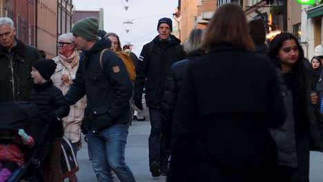 Families-and-couples-walk-on-shopping-street-in-Stockholm,-slomo