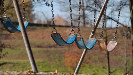 Empty-Swings-in-a-Playground-on-a-Sunny-Day,-Close-Up,-Slow-Motion