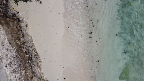 Birds-eye-view-of-beach-shore-waves-crashing-drone-shot