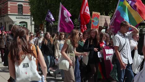 Protesters-with-LGBTQ-and-Women’s-Rights-flags-at-march,-static-slomo