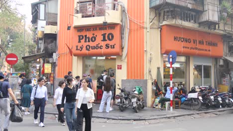 Vibrant-street-scene-outside-Phở-10-Lý-Quốc-Sư,-a-bustling-restaurant-in-Hanoi