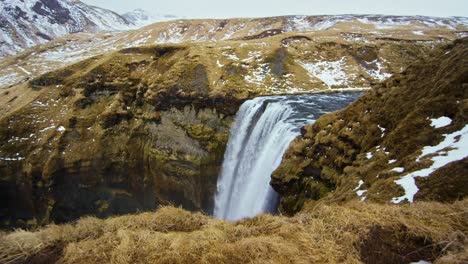 Stunning,-magical-natural-scenery-featuring-the-Kirkjufell-waterfall-near-a-volcano,-captured-in-4K-Drone,-aerial-cinematic-effect-showcasing-the-beautiful-landscape-of-Iceland