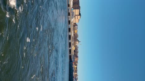 Stockholms-Skeppsbron-Und-Nationalmuseum,-Blaues-Wasser-Mit-Eisschollen,-Sonniger-Tag,-Hochformat