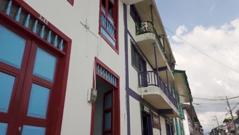 POV-Looking-Up-Walking-Past-Colonial-Style-Wooden-Balconies-in-Filandia-Colombia