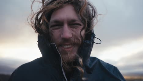 Medium-close-up-of-a-male-hiker-in-the-wilderness-laughing-as-his-long-hair-blows-in-the-wind