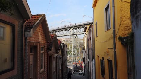 Toma-Descendente-De-Una-Calle-Estrecha-En-Gaia-Por-El-Puente-Dom-Luis-I-En-Oporto,-Portugal.