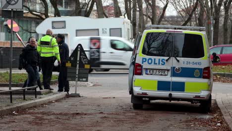 Swedish-uniformed-police-officers-stand-and-talk-by-van-in-Stockholm
