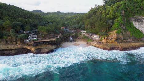 Drone-Retrocede-Sobre-La-Playa-De-Banyu-Tibo-Y-Aguas-Cristalinas-Azules-En-Indonesia
