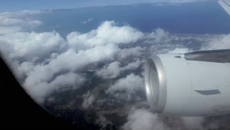 Eine-Aufnahme-Aus-Der-Ich-Perspektive-Aus-Der-Kabine-Eines-Fliegenden-Flugzeugs,-Mit-Blick-Aus-Dem-Fenster-Auf-Eines-Der-Flügeltriebwerke,-Während-Es-Durch-Die-Dünnen-Wolken-Fliegt