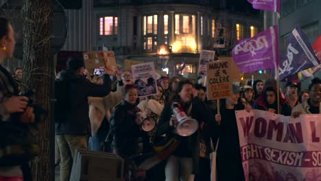 Women's-rights-activists-marching-with-banners-and-colorful-flags-at-night