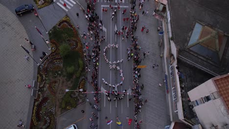 Aerial-View-of-Children-in-National-Folk-Costumes-Dancing-During-Licidersko-Srce-Folklore-Festival-in-Uzice,-Serbia,-High-Angle-Drone-Shot