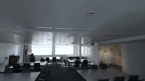 Ein-Panoramablick-Auf-Den-Leeren-Sitzungssaal-Oder-Konferenzraum,-Ausgestattet-Mit-Stühlen-Und-Tischen,-Das-Professionelle-Ambiente-Und-Die-Potenzielle-Zusammenarbeit,-Die-In-Unternehmensumgebungen-Herrschen
