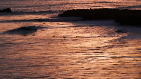 Reflexión-Del-Atardecer-Sobre-El-Océano-Pacífico-En-California-Con-Surfistas-Y-Olas