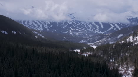 Ten-Mile-Breck-Peaks-Breckenridge-Ski-resort-town-Vail-Epic-Ikon-Pass-aerial-drone-landscape-cloudy-fog-sunny-winter-morning-ski-trail-runs-Summit-County-Tiger-fork-road-Rocky-Mountains-pan-up-forward