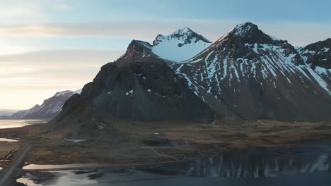 Die-Von-Einer-4K-Drohne-Aufgenommenen-Luftaufnahmen-Zeigen-Die-Atemberaubende-Aussicht-Auf-Den-Hoch-Aufragenden-Berggipfel-Kirkjufell