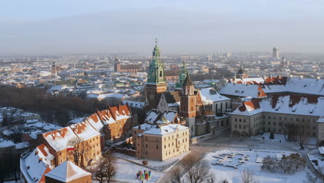 Panorama-of-snow-covered-Wawel-castle-and-Old-Town-at-magic-morning-with-soft-sun-light-during-winter,-Krakow,-Poland
