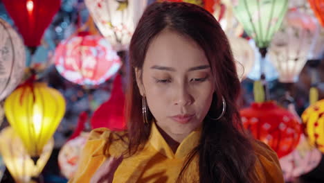 Woman-in-yellow-Ao-Dai-admiring-lanterns-at-night-in-Hoi-An