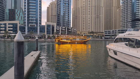 Dubai-Marina-UAE,-Moored-Yachts,-Touristic-Boat-and-Skyscrapers-at-Evening