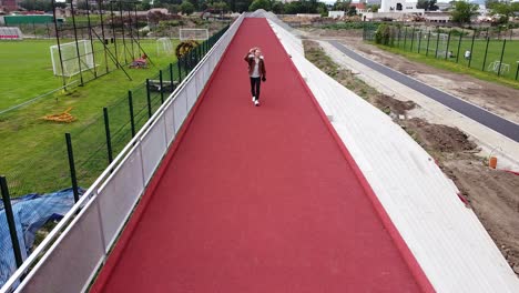 masking-stable-shot-of-traveller-with-backpack-walking-on-colorful-red-stripe-walking-towards-camera