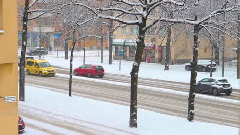 Blue-public-bus-and-cars-drive-on-Stockholm-street-in-winter,-static