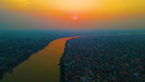 Vista-Aérea-Sobre-El-Concurrido-Paisaje-Urbano-Ribereño-De-Dhaka-En-El-Río-Buriganga-Bajo-Una-Colorida-Atmósfera-Contaminada-De-Bangladesh