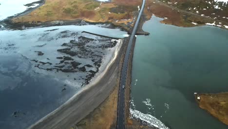 A-breathtaking-4K-aerial-footage-of-Iceland's-iconic-ring-road,-captured-by-a-drone,-showcasing-its-unique-cinematic-landscape-with-a-vehicle-traversing-the-scenic-route