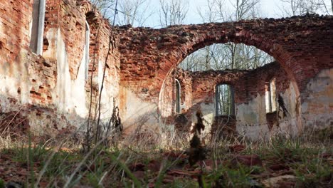 Low-angle-view-with-grass-of-abandoned-church-brick-wall-arch-shape-interior