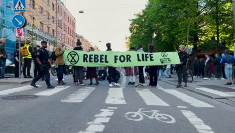 Zeitlupe-Eines-Polizisten,-Der-Bei-Einer-Demonstration-Vor-Einem-Banner-Läuft