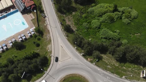 Aerial-View,-Zlatibor-Mountain-Serbia,-Traffic-on-Roundabout-Revealing-Touristic-Area-With-Houses-and-Hotels-on-Sunny-Summer-Day
