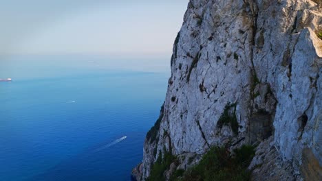 Static-shot-of-boats-sailing-on-ocean-with-a-hill-beside-it