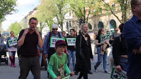 Familien-Marschieren-Mit-Stop-Ökozid-Schildern-Bei-Klimaprotestkundgebung,-Zeitlupe