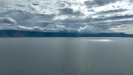 View-across-Lake-Toba,-expansive-blue-waters-stretching-out-in-distance