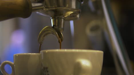 Kaffee-Wird-Morgens-In-Einem-Café-In-Zwei-Tassen-Gegossen,-Menschen-Gehen-Im-Hintergrund,-Nahaufnahme