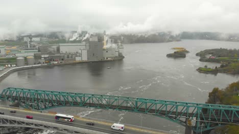 A-wide-Aerial-shot-of-the-Irving-Pulp-and-Paper-plant-in-the-reversing-falls-with-a-large-bridge-next-to-it