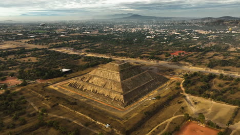 Drone-shot-diving-toward-the-Pyramid-of-the-sun,-sunrise-in-Teotihuacan,-Mexico