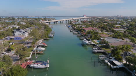 Drone-flying-up-water-channel-of-coastal-Florida-luxury-residential-neighborhood