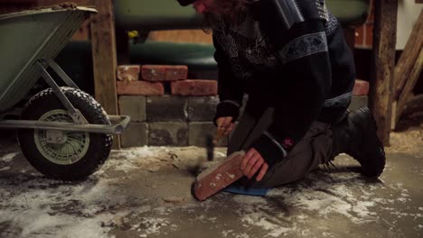 Man-Cleaning-Used-Red-Brick-With-Claw-Hammer-In-Farm-House