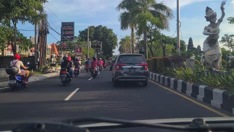 Busy-City-Traffic-on-Bali-Island,-Indonesia,-Motorbikes-and-Cars-on-Road,-Driver's-POV