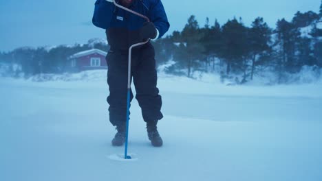 Mann-Bohrt-Loch-In-Zugefrorenen-See-Zum-Eisfischen---Nahaufnahme