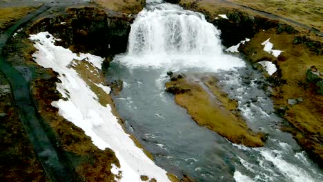 A-4K-drone,-aerial,-cinematic,-and-unique-landscape-shots-of-an-Iceland-waterfall-with-snow-melts-on-the-side