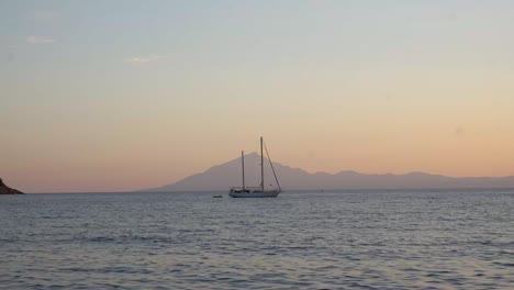 Boat-Isolated-On-Sunset-Beach-With-Mountain-Background