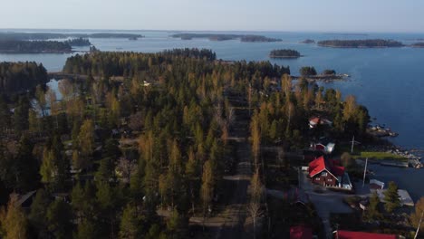 Wide-aerial-of-red-houses-and-distant-islands-in-Swedish-archipelago