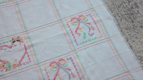 Slow-panning-shot-showing-the-designs-on-a-cross-stitched-baby-blanket