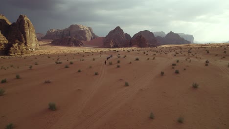 Gente-Caminando-Por-El-Desierto-De-Wadi-Rum-árabe,-Oriente-Medio,-Jordania,-Vista-Aérea-De-Drones