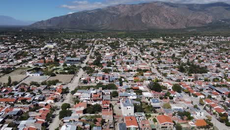 Low-aerial-flyover:-Cafayate-town-in-high-mountain-plateau,-Argentina