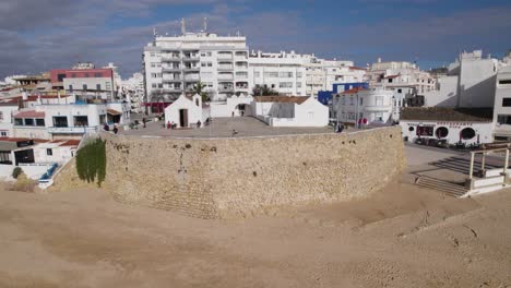 Touristen-Besichtigen,-Gebäude-An-Der-Küste-Von-Armacao-De-Pera,-Portugal,-Luftaufnahme