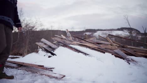 Der-Mann-Stapelt-Die-Holzbretter-Im-Schnee-In-Indre-Fosen,-Provinz-Trondelag,-Norwegen-–-Statische-Aufnahme