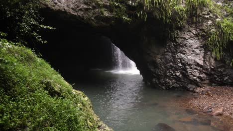 View-of-Natural-Arch-waterfall-from-outside-the-cave-and-the-walking-trail,-Natural-Bridge,-Springbrook-National-Park